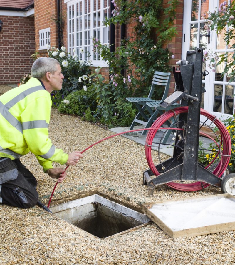 BUCKINGHAM, UK - October 16, 2019. A professional drain cleaning engineer inspects a blocked household drain